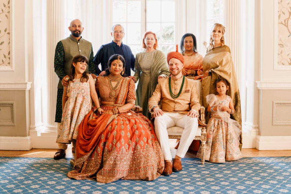 indian bride and polish groom in indian wedding attire with family 