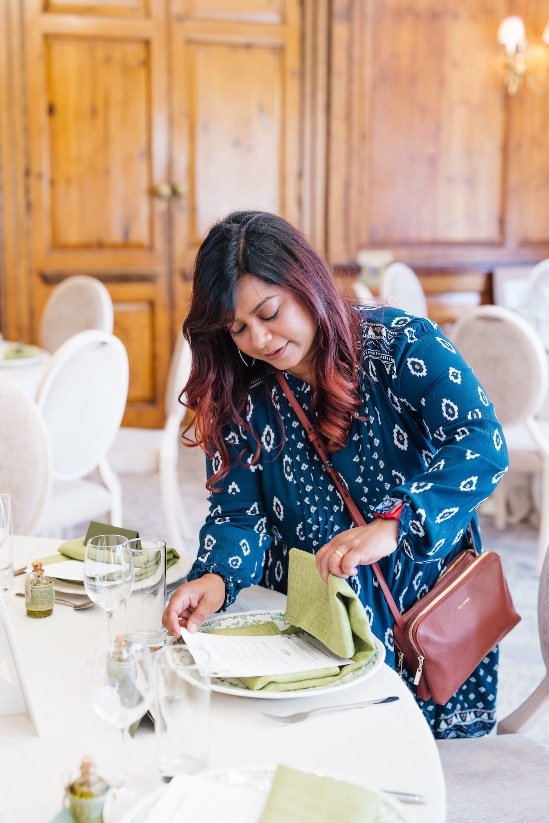 Luxury wedding planner Knots and Nuptials setting the table at Hedsor House for a multicultural wedding
