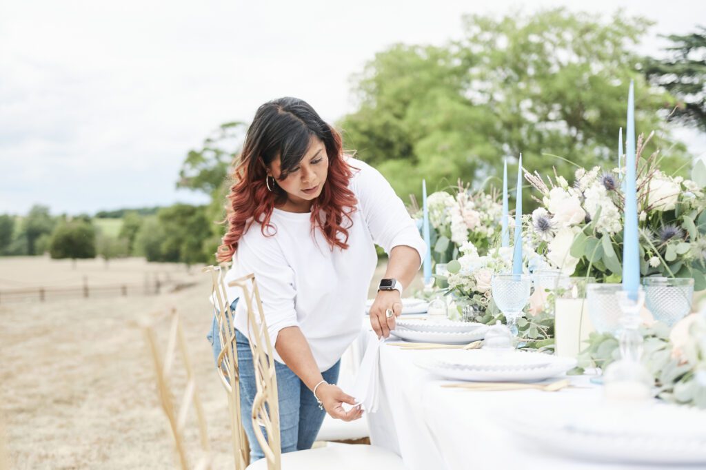 Luxury wedding day coordinator Nalini Raman styling an outdoor marquee tablescape at Turvey House Bedfordshire